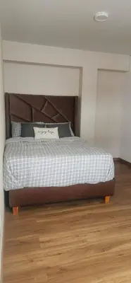 a bedroom with a bed with a wooden floor at Depa UMBRA, one block from Rebagliati Hospital in Lima