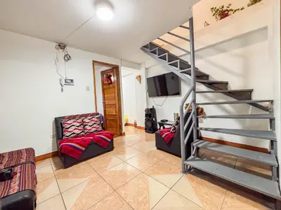 a living room with a spiral staircase and a couch at Los Chullos in Cusco