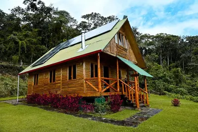 a log cabin with a solar roof on top of it at Montecatini Ecolodge in Oxapampa