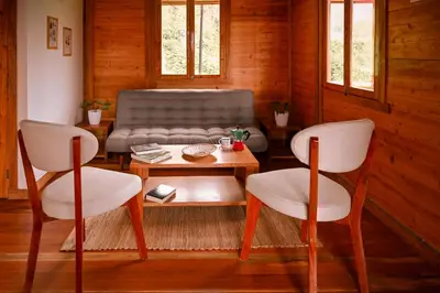 a living room with a couch and a table and chairs at Montecatini Ecolodge in Oxapampa