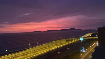a night view of a highway with lights and the ocean at Lovely apartment in front of malecon! in Lima