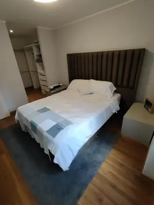 a bedroom with a large white bed with a wooden headboard at GOLD DÚPLEX único c PISCINA PRIVADA MIRAFLORES P República 5655 in Lima