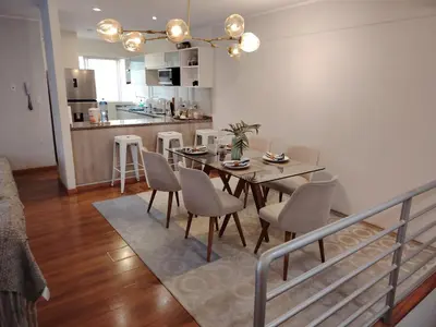 a dining room and kitchen with a table and chairs at GOLD DÚPLEX único c PISCINA PRIVADA MIRAFLORES P República 5655 in Lima