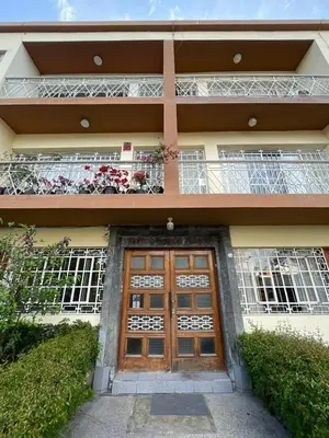 a building with a door and a balcony with flowers at Céntrico Dpto Puca Lima a 2 cuadras de Hospital Rebagliati y Real Plaza Salaverry in Lima