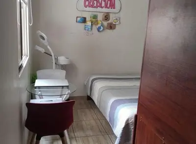 a small room with a bed and a table with a desk at Lascondes in Chosica