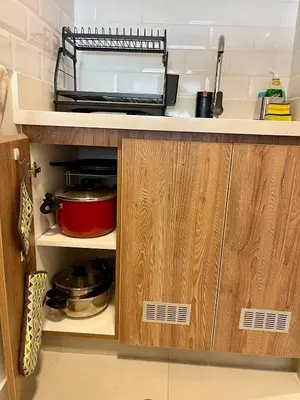 a kitchen with wooden cabinets and a red pot at Calm and Cozy Flat in San Borja in Lima