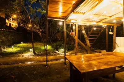 a tent with a wooden table in a yard at night at Pinkuylluna Lodge in Ollantaytambo
