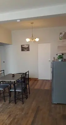 a dining room with a table and chairs and a refrigerator at Cozy loft in the heart of the city in Cusco