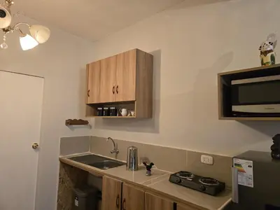 a kitchen with a sink and a microwave at Cozy loft in the heart of the city in Cusco