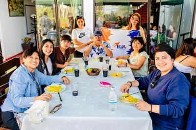 a group of people sitting around a table eating food at Barón de Huaura Hotel Boutique in Huaura