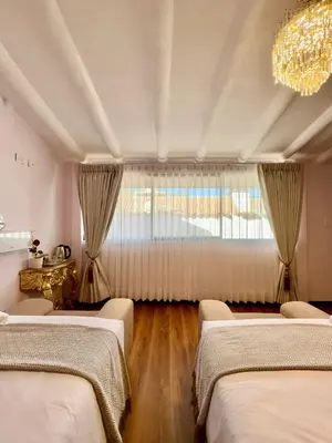 a bedroom with four beds and a chandelier at Ayni Boutique Hotel in Cusco
