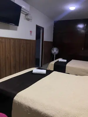 a hotel room with two beds and a flat screen tv at Casa Grau Chincha in Chincha