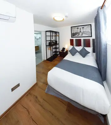 a bedroom with a large white bed and wooden floors at Casa Atempo Boutique Hotel in Lima