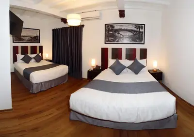 a hotel room with two beds and a television at Casa Atempo Boutique Hotel in Lima