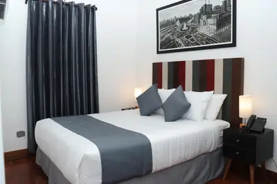 a bedroom with a white bed with a black curtain at Casa Atempo Boutique Hotel in Lima
