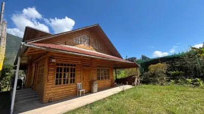 a wooden cabin with a porch in a field at CABAÑAS RANCH OXaPAMP4 in Oxapampa