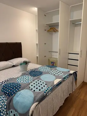 a bedroom with a bed with a blanket on it at TyB apartment in Lima