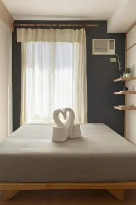 two swans sitting on a bed in front of a window at Mario Vera Chavez in La Molina
