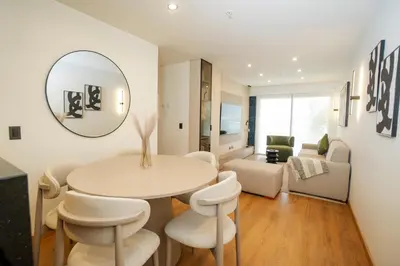 a living room with a table and chairs and a mirror at Luxurious Apartment in the heart of Miraflores in Lima