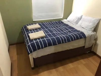 a bed in a room with two towels on it at Departamento familiar Lucrepata in Cusco
