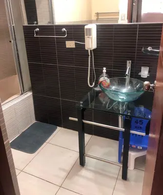 a bathroom with a sink and a glass table at Departamento familiar Lucrepata in Cusco