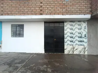 a black door on the side of a building at IN FRONT OF THE NEW AIRPORT Hospedaje - A y C Taxi Free - Airport - Apartment on the 1st Floor in Lima