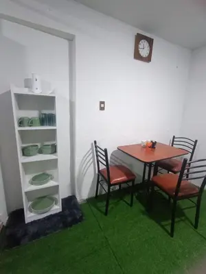 a dining room with a table and chairs and a clock at IN FRONT OF THE NEW AIRPORT Hospedaje - A y C Taxi Free - Airport - Apartment on the 1st Floor in Lima
