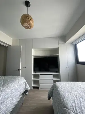 a bedroom with two beds and a flat screen tv at LimaeStays Exclusive penthouse in downtown Barranco in Lima