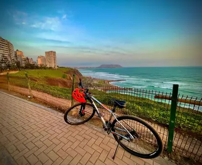 a bike parked next to a fence next to the ocean at Close to the beach, Big beds, Malecon Miraflores in Lima