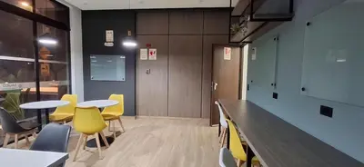 a room with tables and yellow chairs and a counter at Acogedor departamento 1 dormitorio in Lima