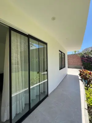 an empty house with glass windows and a balcony at La Casita de Condoray - Lunahuana in Lunahuaná