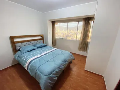 a bedroom with a bed with a large window at Apartment in downtown Huancayo in Huancayo