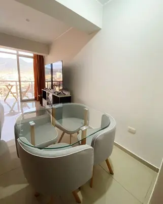 a living room with a glass table and chairs at Apartment in downtown Huancayo in Huancayo