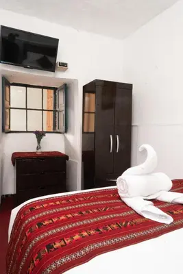 a bedroom with a bed with a swan on it at HOTEL PALACE DIAZ inn in Cusco