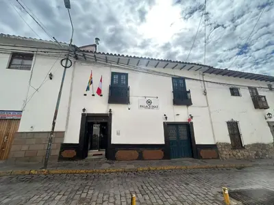 a white building with two flags on it at HOTEL PALACE DIAZ inn in Cusco