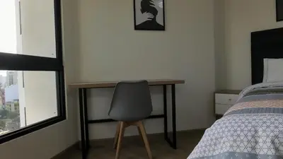 a bedroom with a desk and a chair next to a bed at Eurocasas Villa Velarde in Lima