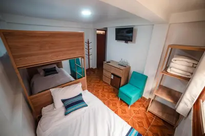 a bedroom with a bunk bed and a blue chair at Casa Andora in Machu Picchu