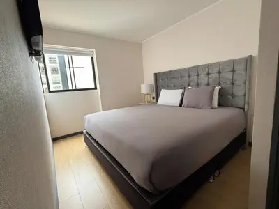 a bedroom with a large bed and a window at Departamento Style in Lima