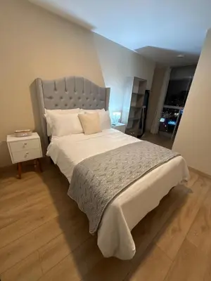 a bedroom with a large bed with a gray headboard at Modern apartment with great view in Lima in Lima
