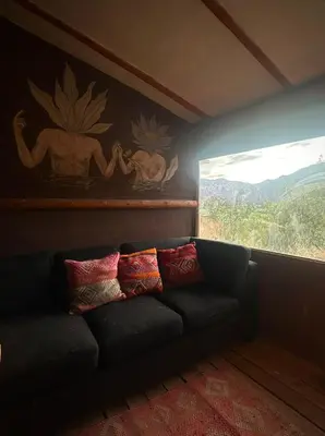 a black couch in a room with a window at Casa Divina Medicina in Urubamba