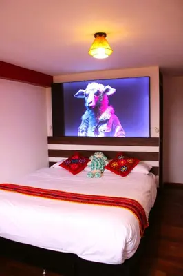 a bedroom with a bed with a television with a sheep on it at Mirador All Sur Cusco in Cusco