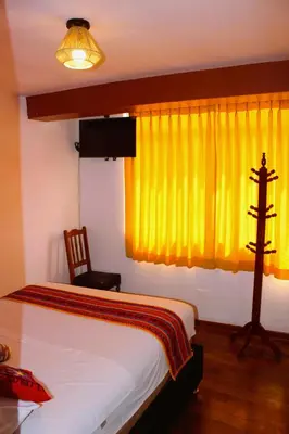 a bedroom with a bed and a yellow window at Mirador All Sur Cusco in Cusco