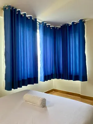a bed with blue curtains in a bedroom at Hotel Naciones Unidas in Lima