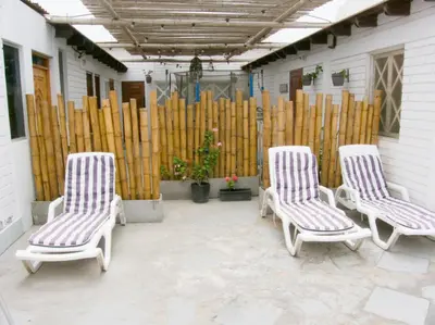 three chairs sitting on a patio next to a wooden fence at Departamento con salida a la playa Punta Rocas 202 in Punta Negra