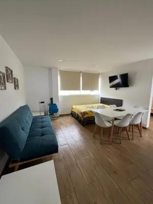 a living room with a couch and a table and a bed at Departamento con salida a la playa Punta Rocas 202 in Punta Negra