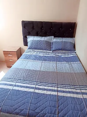a bedroom with a bed with a blue and white bedspread at Departamento amoblado y Estacionamiento Gratis in Lima