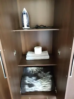 a cupboard with a towel and a roll of toilet paper at Departamento amoblado y Estacionamiento Gratis in Lima