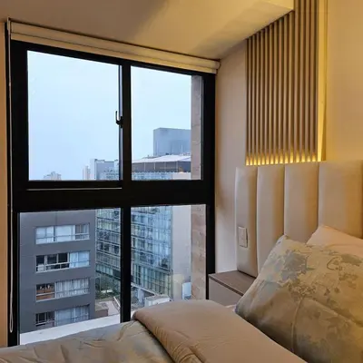a bedroom with a bed and a large window at Modern Brand New Apartment in Miraflores in Lima