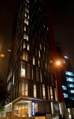 a tall building at night with a street light at Ramada Encore by Wyndham Lima San Isidro in Lima