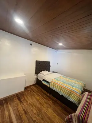 a small bedroom with a bed and a desk at Redy's House in Cusco